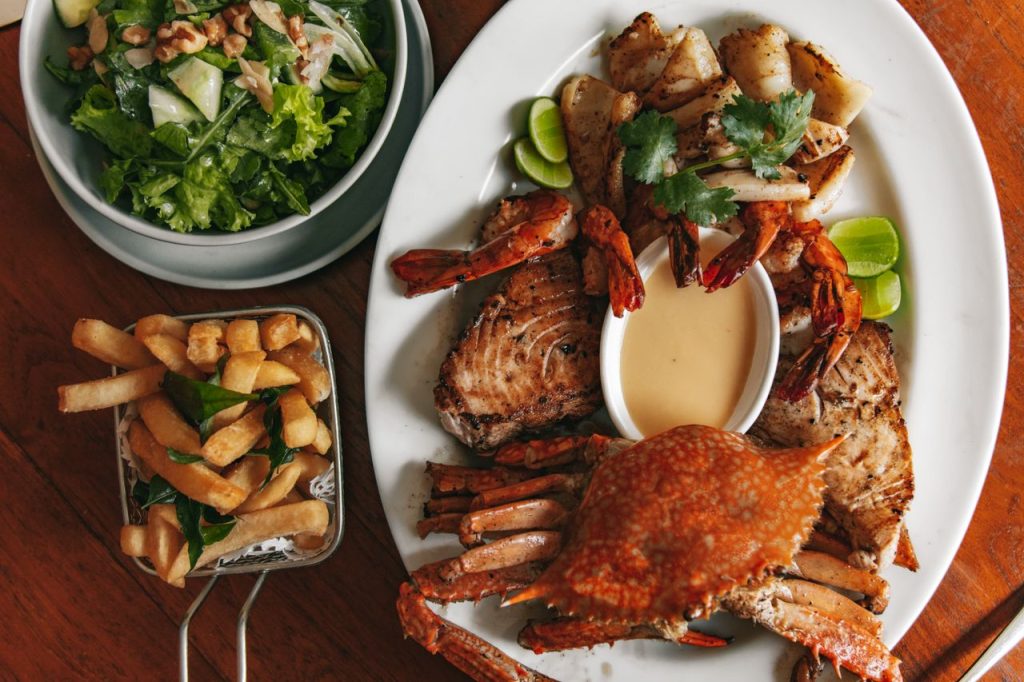 Delicious seafood platter with crab, shrimps, and a fresh vegetable salad.